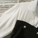 Contrast-Panel Top – Featuring Pearl Button Accents, a Flattering Peplum Silhouette, and a Timeless Black & White Palette