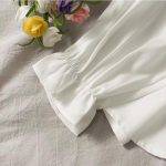 Contrast-Panel Top – Featuring Pearl Button Accents, a Flattering Peplum Silhouette, and a Timeless Black & White Palette